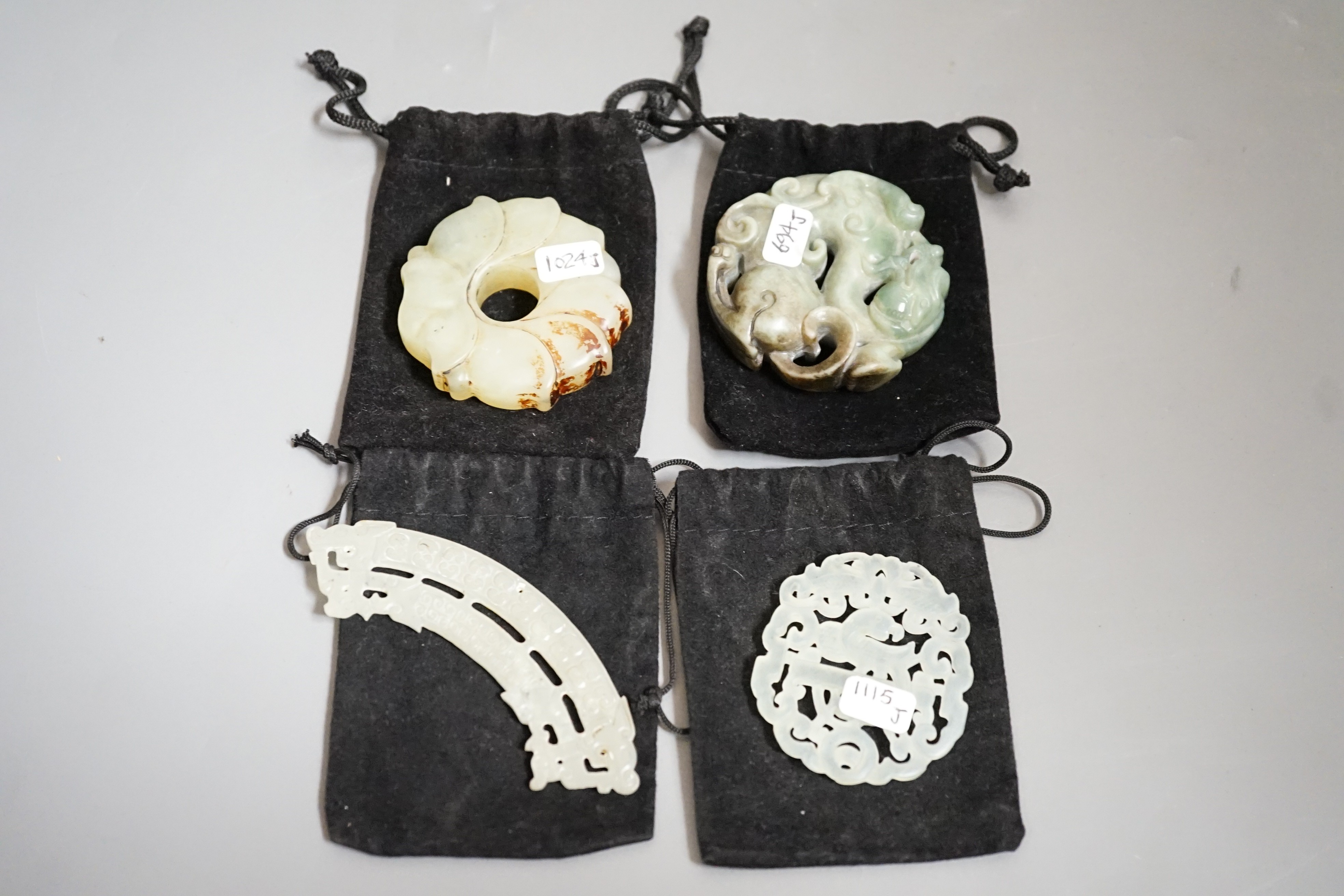 Three Chinese jade celadon roundels/pendants and a huang plaque, carved dragon roundel 5.5 cms diameter (4)
